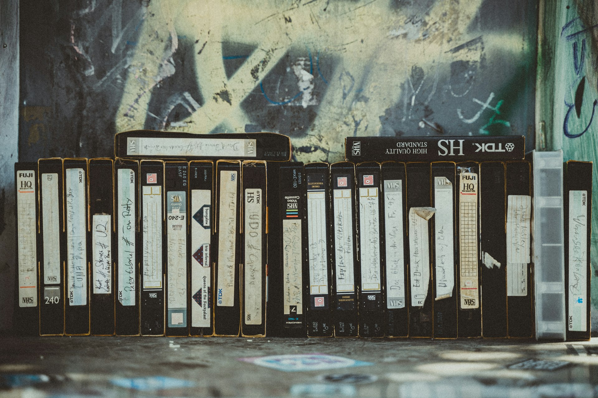 Film-, Foto und Videoarchive retten. eine Reihe von vhs kassetten stehen vor einer Grafittiwand